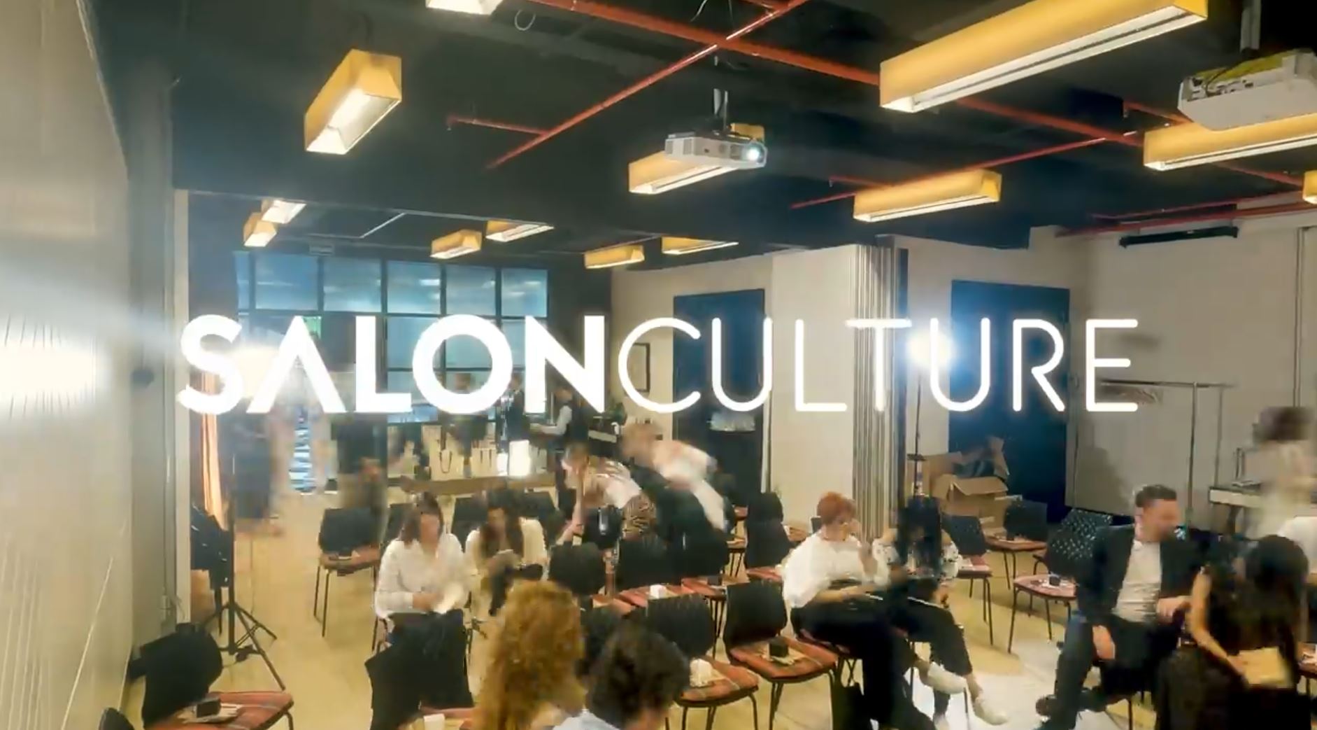 Salon Culture classroom during a course: rows of attendees seated beneath the SALON CULTURE wordmark overlaid on the image, expressing the company's in-house education programme.