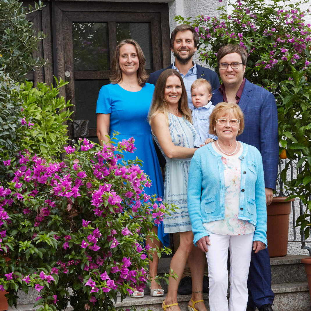 The Breidenbach family (Wild Beauty owners) posing on the steps of their house surrounded by blooming bougainvillea.