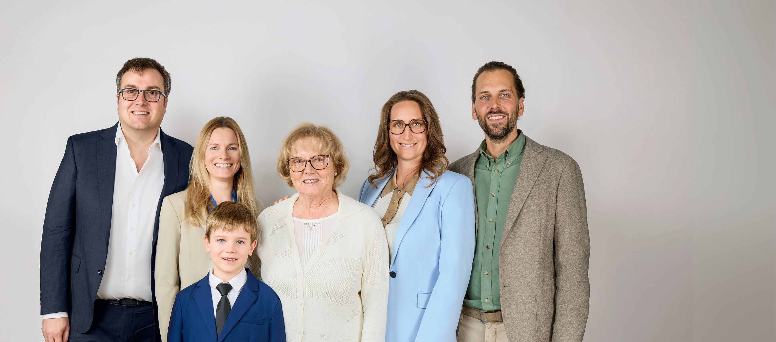Group portrait of the Wild Beauty sales and management team in business attire with a child in front.